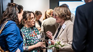 Gäste tauschen sich nach der Podiumsdiskussion aus. 