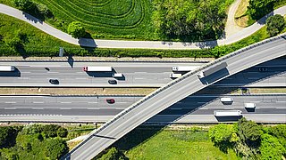 Overhead view of a busy highway with trailer trucks globally connected in a green environment