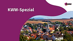 Dorf im Herbst mit einer Kirche und einem mit Solarmodulen ausgestatteten Haus im Zentrum