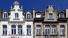 Zweistöckige Fassade mit Giebel, links frisch renoviert in Weiß, rechts unrenoviert mit sichtbarem Verwitterungsschmutz.