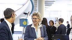 Zwei Personen unterhalten sich bei einer Veranstaltung.