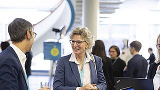 Zwei Personen unterhalten sich bei einer Veranstaltung.