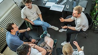 5 Personen des SET Mentoring Programms von oben fotografiert wie sie in einem Kreis zusammensitzen und miteinander sprechen