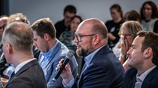 Ein Gast stellt eine Publikumsfrage