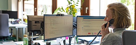 Eine Frau spricht am Telefon in einem Büro.