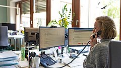 Eine Frau spricht am Telefon in einem Büro.
