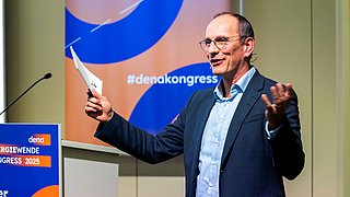 Christian Stolte steht auf dem Podium und hält eine Rede. 