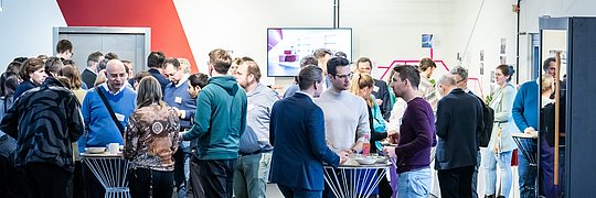 Mehrere Teilnehmerinnen und Teilnehmer bei einer Pause bei einer Veranstaltung.
