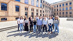 Eine Gruppe von Menschen steht vor einem Gebäude.