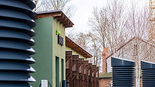 Eine Reihe schwarzer Rohre vor einem Gebäude.