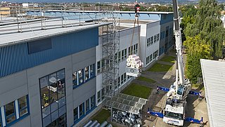 Drohnenfoto, Berufsschulcampus von der Seite, Kran auf einem LKW