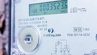 Nahaufnahme eines digitalen Stromzählers mit LCD-Anzeige und technischen Beschriftungen