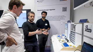 dena-Mitarbeitende erklären das Modell des r2d2 am Tag der offenen Tür im BMWE