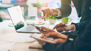 Menschen am Laptop bei einer Besprechung