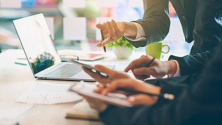 Menschen am Laptop bei einer Besprechung