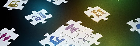 Puzzleteile auf denen verschiedene Energiesymbole gedruckt sind.