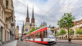 Eine fahrende Tram an einer Haltestelle in Halle an der Saale