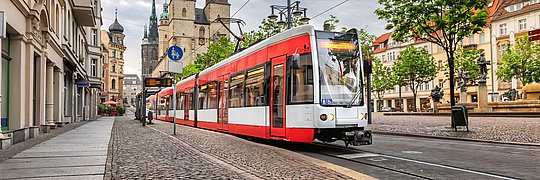Eine fahrende Tram an einer Haltestelle in Halle an der Saale