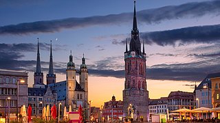 Marktplatz in Halle an der Saale bei Sonnenuntergang mit Marktkirche Unser Lieben Frauen und rotem Turm