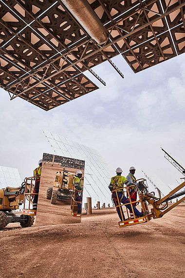 Arbeiter montieren einen Spiegel am solarthermischen Kraftwerk in Ouarzazate, Marokko.