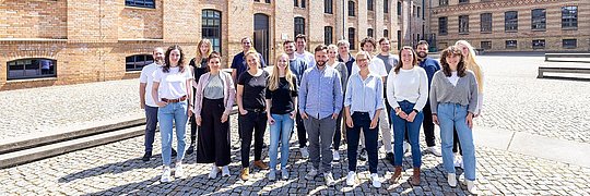Eine Gruppe von Menschen steht vor einem Gebäude.