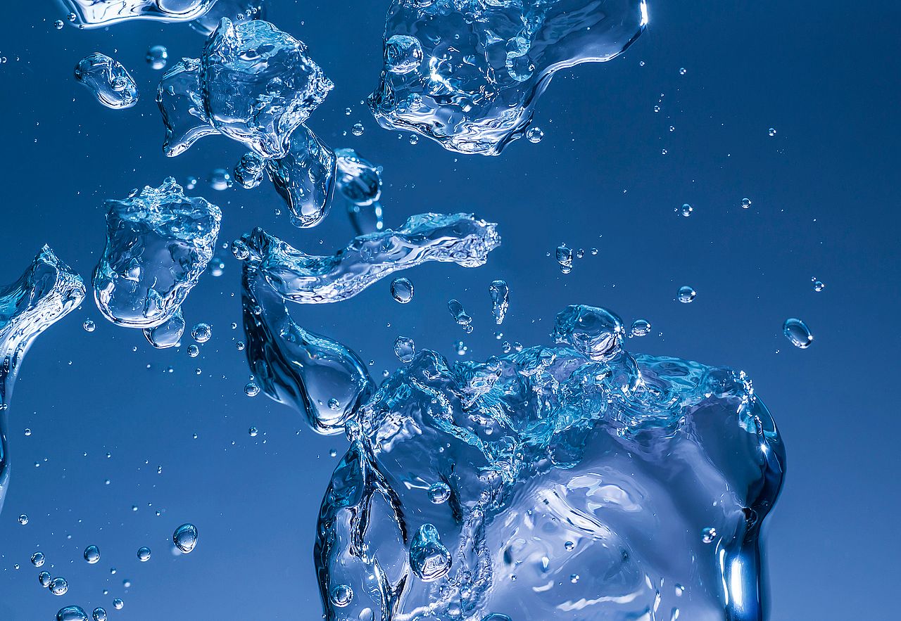 Wasserblasen und -tröpfchen in verschiedenen Formen und Größen, die in einer blauen Umgebung schweben.