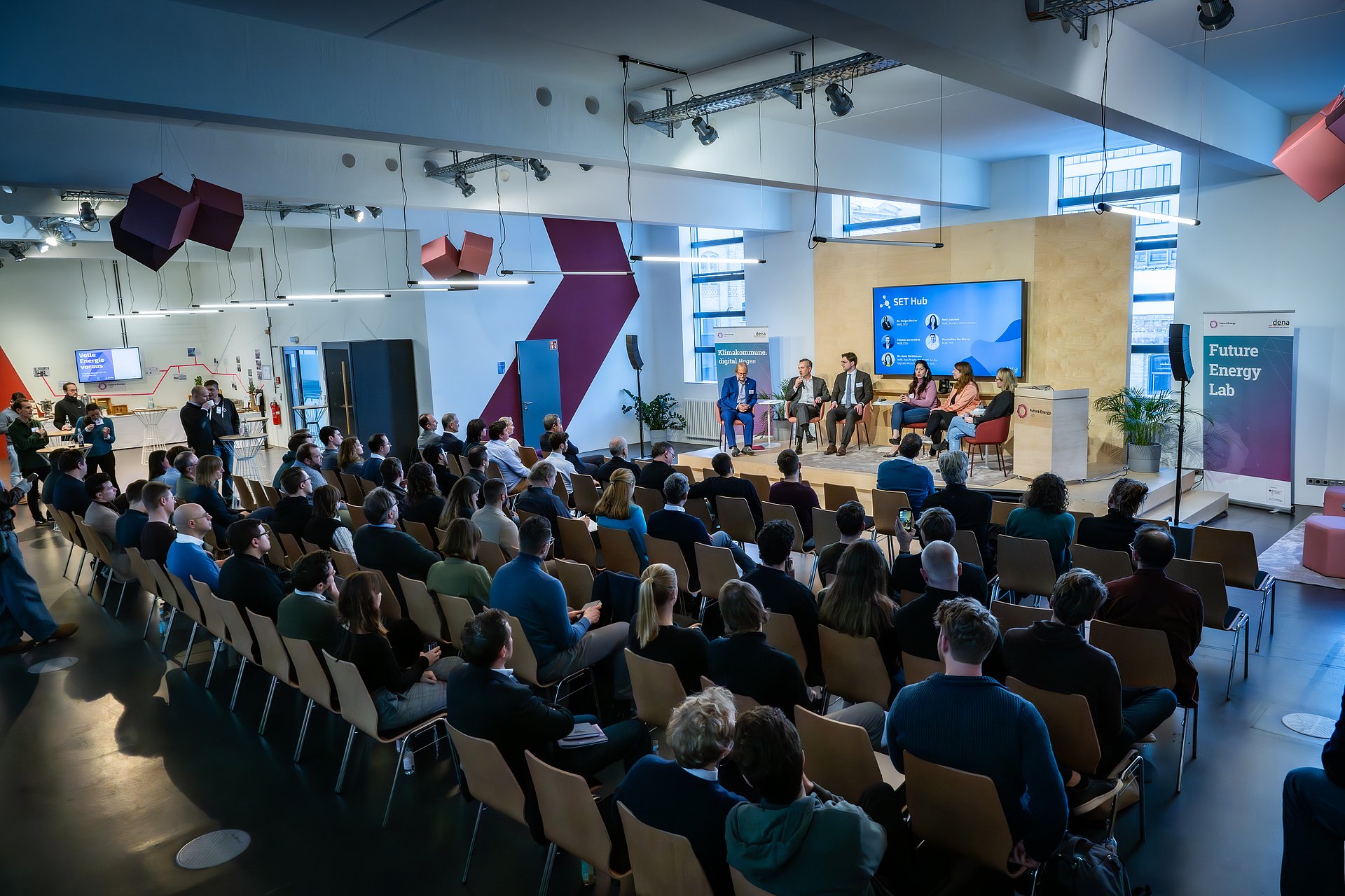 Gäste sitzen in Reihenbestuhlung vor der Bühne im Future Energy Lab